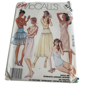 Puede incluir: Patrón de costura vintage de McCall's con ilustraciones de diseños de lencería. El paquete de patrones muestra varios estilos, incluyendo enaguas, faldas y camisolas. El texto en el paquete incluye "Easy McCall's" y "Overlock Sewing".