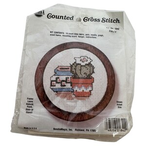 May include: A cross-stitch kit featuring a round wooden frame with a stitched design of two potted cacti. The kit includes Aida fabric, yarn, a needle, and instructions. The packaging reads "Gounted Gross Stitch".