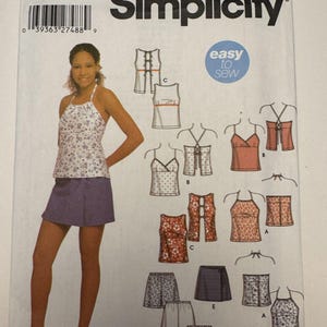 May include: Simplicity sewing pattern 5160, size BB 11/12-15/16. The pattern includes instructions for tops and shorts. The cover features a woman wearing a floral halter top and a purple skirt. The words "easy to sew" are also on the cover.