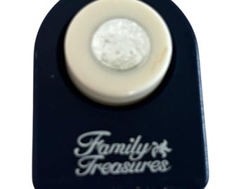 May include: A dark blue paper punch with a cream-colored circular punch head. The text "Family Treasures" is printed in white script on the front of the punch. The punch is designed for crafting and scrapbooking.