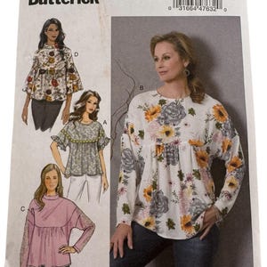 May include: Butterick sewing pattern B6593. The pattern features illustrations of various blouses with floral designs. The main image shows a woman wearing a white blouse with long sleeves and a floral print. The pattern includes sizes 6-8-10-12-14.