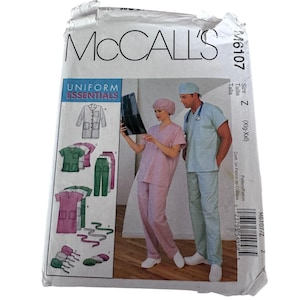 May include: A McCall's M6107 sewing pattern envelope for Uniform Essentials. The front shows illustrations of scrub tops, pants, and caps, alongside a photograph of two people wearing light purple and light blue scrub sets and matching caps.