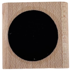 May include: A square wooden block featuring a large, centered circular cutout. The natural light-colored wood grain is visible on the surface surrounding the deep black, circular interior space, creating a high-contrast geometric design.