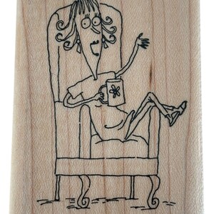 May include: Wooden stamp with a whimsical illustration of a person lounging in a chair, holding a mug with a flower design. The stamp includes the text "I MISS HEARING FROM YOU..." and the copyright information.