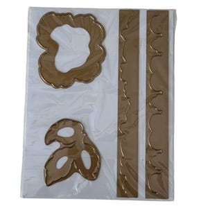 Peut inclure: Un ensemble de quatre matrices de découpe en métal couleur bronze métallique disposées sur une feuille de support blanche dans une pochette en plastique transparent. Le lot comprend deux formes organiques nuageuses et deux bandes étroites.