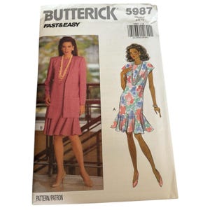 May include: A vintage Butterick sewing pattern, featuring illustrations of a pink suit and a floral print dress. The pattern number is 5987, with the words "Fast & Easy" printed on the top left corner.