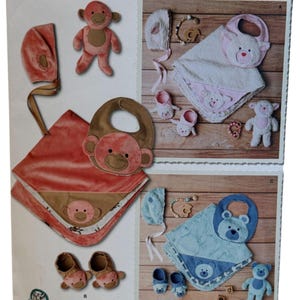 May include: Simplicity pattern 8623 features baby items. The pattern includes a monkey-themed set with a blanket, bib, booties, and a stuffed animal. A bear-themed set with a blanket, bib, booties, and a stuffed animal is also included. The pattern is designed and printed in the USA.