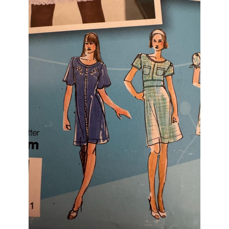 May include: A sewing pattern illustration featuring two dress designs. The left dress is a dark blue button-front style with short sleeves. The right dress is a light green plaid pattern with short sleeves, a round neckline, and two chest pockets.
