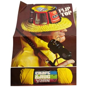 May include: A retro advert showing a man in a yellow crocheted hat decorated with beer labels, holding a fishing rod. Below, a ball of yellow Craft & Rug Yarn is displayed, with the text "Craft & Rug Yarn".