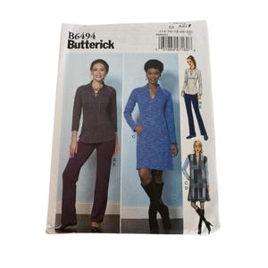 May include: A Butterick sewing pattern, B6494, featuring illustrations of women's clothing designs. The pattern includes a long-sleeved top with lace-up detail, a blue dress, a collared shirt with pants, and a patterned vest with a dress. The pattern size is ES 25 (14-16-18-20-22).