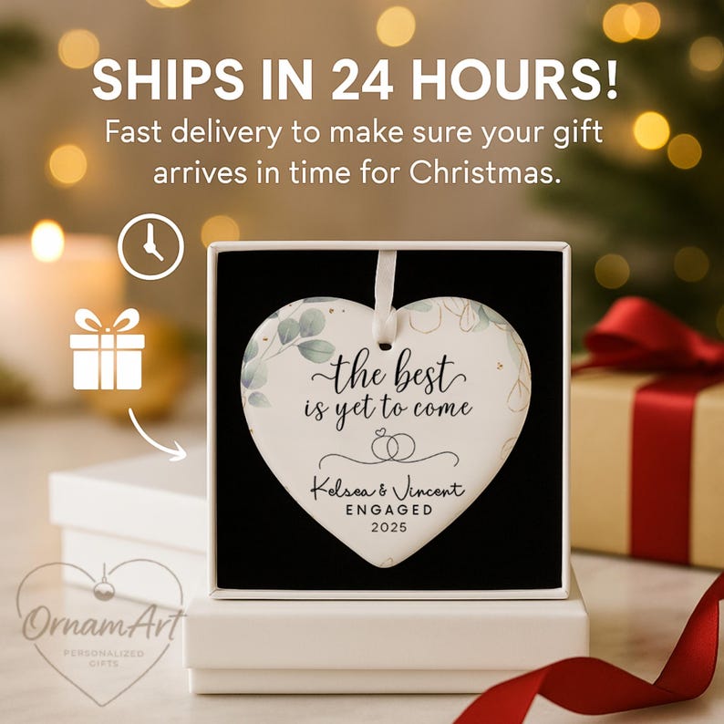 May include: Heart-shaped ornament with the text "the best is yet to come" and the names "Kelsea & Vincent ENGAGED 2025". The ornament has a white background with green and gold accents, and is displayed in a gift box.