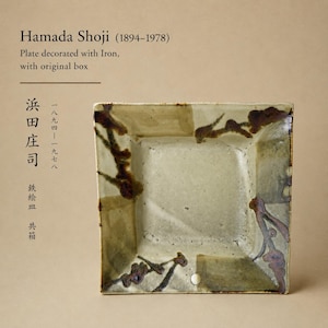 May include: Square ceramic plate with a light beige and brown color scheme. The plate features dark brown iron decoration and the text "Hamada Shoji (1894-1978) Plate decorated with Iron, with original box".