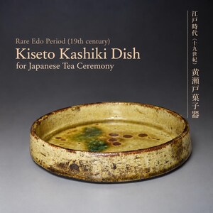 May include: A round, shallow ceramic dish with a yellow-toned glaze, featuring dark brown and green spots on the interior surface. The text reads: Rare Edo Period (19th century) Kiseto Kashiki Dish for Japanese Tea Ceremony, plus Japanese characters.