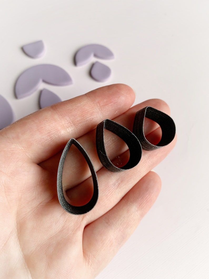 May include: Three black teardrop-shaped cookie cutters of different sizes.