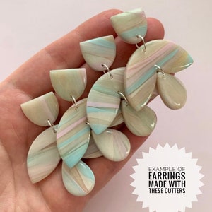 May include: A pair of handmade earrings with a marbled design in shades of blue, green, and pink. The earrings are made with polymer clay and have a delicate, feminine look. "EXAMPLE OF EARRINGS MADE WITH THESE CUTTERS" is written on a white starburst.