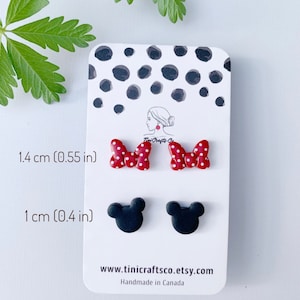 May include: A set of four polymer clay earrings. Two red and white polka dot bow earrings, each measuring 1.4 cm in diameter. Two black Mickey Mouse head earrings, each measuring 1 cm in diameter. The earrings are displayed on a white card with black polka dots. The card also includes the text "Tini Crafts-Co", "1.4 cm (0.55 in)", "1 cm (0.4 in)", "www.tinicraftsco.etsy.com", and "Handmade in Canada".