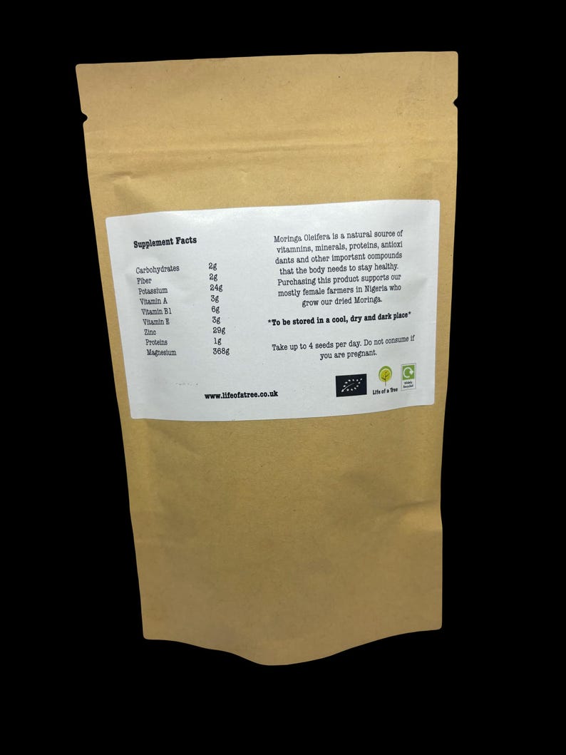 Puede incluir: Una bolsa de papel marr&oacute;n con una etiqueta blanca que enumera los datos nutricionales de las semillas de Moringa Oleifera. La etiqueta incluye una descripci&oacute;n del producto e instrucciones de almacenamiento y consumo. La direcci&oacute;n del sitio web "www.lifeofatree.co.uk" est&aacute; impresa en la parte inferior de la etiqueta.