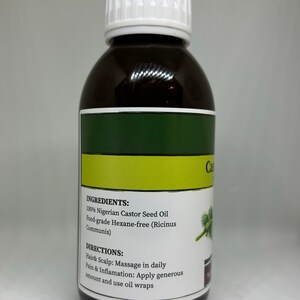 Op de afbeelding: Een donkerbruine fles ricinusolie met een witte dop. Het etiket bevat tekst over ingredi&euml;nten en gebruiksaanwijzingen. De fles bevat 100% Nigeriaanse ricinusolie.