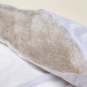 May include: A white pillow with a zippered opening revealing the white fiberfill inside.