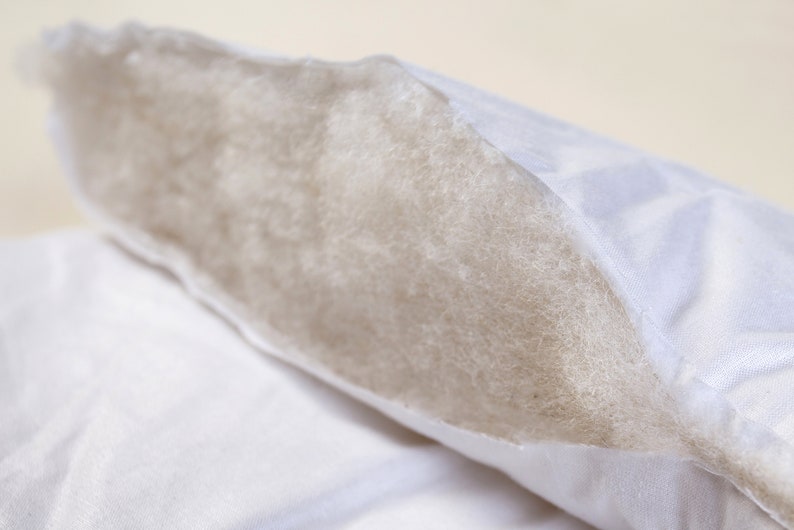 May include: A white pillow with a zippered opening revealing the white fiberfill inside.