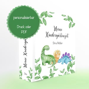 Könnte beinhalten: Ein weißer Buchumschlag mit grünem Blattwerkrand und drei Comic-Dinosauriern. Der Text auf dem Umschlag lautet "Meine Kindergartenzeit" und "Sina Müller".