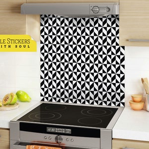 Może przedstawiać: Czarno-białe geometryczne naklejki na płytki zastosowane na kuchennym fartuchu nad stalową płytą grzewczą. Naklejki na płytki mają powtarzający się wzór czarnych i białych trójkątów. Tekst "TILE STICKERS WITH SOUL" jest widoczny w lewym górnym rogu obrazu.