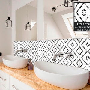 Peut inclure: Sticker de carrelage géométrique noir et blanc avec un motif en losange. Le sticker est appliqué sur un mur de salle de bain au-dessus d'un meuble double vasque.