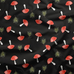 Könnte beinhalten: Ein schwarzer Stoff mit einem sich wiederholenden Muster aus roten und weißen Pilzen und grünen Kiefernnadeln.