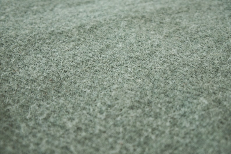 May include: Close-up of a soft, green, fuzzy fabric texture.
