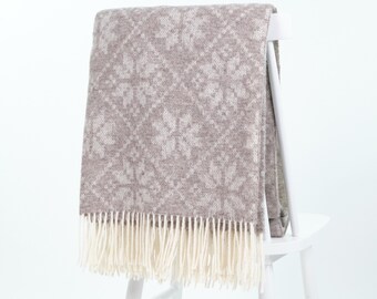 Scandinavian wool throw blanket with Nordic snowflake pattern, cozy beige sofa decor