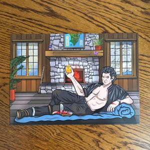 May include: Cartoon illustration of a man reclining on a blue blanket, holding a drink. The background features a fireplace, map, and window, set in a cabin. The artwork has a cartoon style.