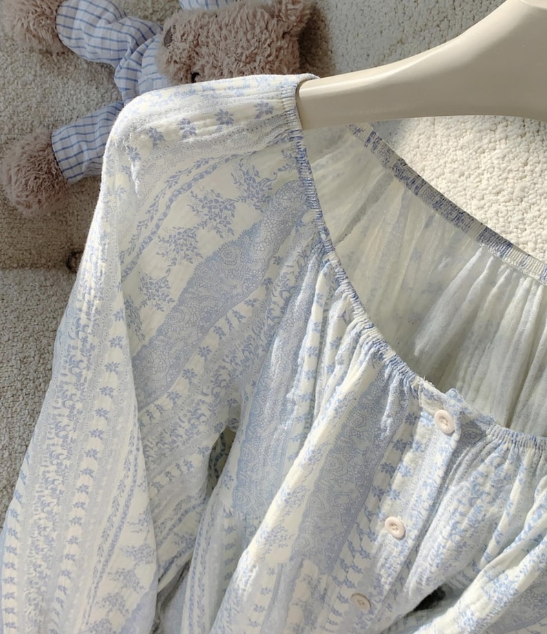 May include: A white ceramic mug with a black handle and the text "But First, Coffee" in a black, handwritten-style font. The mug is on a white surface.