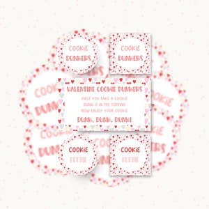 May include: A collection of printable tags featuring a heart pattern in red, pink, and white. The tags include circular and square designs with the text "COOKIE DUNKERS" or "COOKIE FETTIE" and a rectangular card with "VALENTINE COOKIE DUNKERS" instructions.