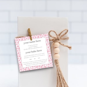 May include: Pink floral patterned card with the text "your name here", "17 cherry tree lane", "London England", "123-456-7990 yourwebster.com", "your bake here", "homemade bakes with known food allergens, included but not limited to", "dairy", "soy", "wheat", "This food is made in a home kitchen and is not inspected by the Department of State Health Services or a local health department".