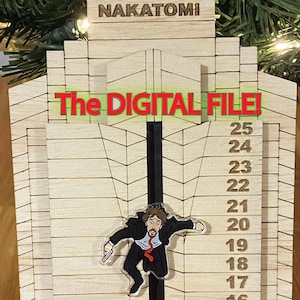 May include: A wooden model of the Nakatomi Plaza building from the film Die Hard, with a character from the film hanging from the side. The building has a number scale on the side, with the character hanging at the 19th floor. The text "The Digital File!" is written above the building.