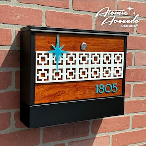 May include: A brown and black mailbox with a white geometric design and a turquoise star. The mailbox has a black base and a turquoise house number "1805".