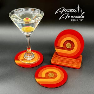 May include: Set of three red, orange, and yellow coasters with a gold glitter accent. The coasters are in a retro 70s style and are perfect for adding a touch of vintage flair to your home decor.
