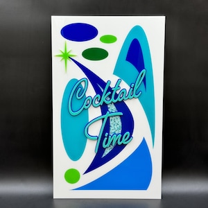 May include: A white sign with blue, green, and turquoise abstract shapes and the text "Cocktail Time" in turquoise lettering.