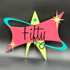 May include: A pink and yellow starburst design with a turquoise swirl. The word "Fifty" is written in black script on the pink section.