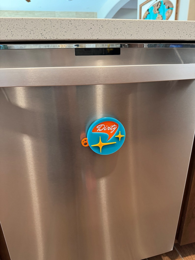 May include: A blue and orange dishwasher magnet with the word "Dirty" in white lettering and two yellow stars.