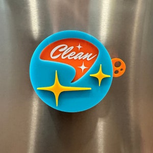 May include: A blue and orange round magnet with the word "Clean" in white lettering and a stylized star design.