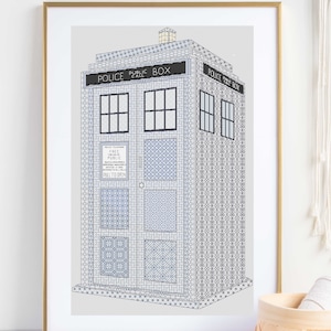 May include: A framed cross-stitch pattern of a blue police box with the text "Police Public Box" and "Police Box" on the front. The box is decorated with a variety of geometric patterns.