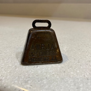 May include: A silver bell with a handle and the inscription "A.N.R.J.A. 1923 Convention Providence, R.I."