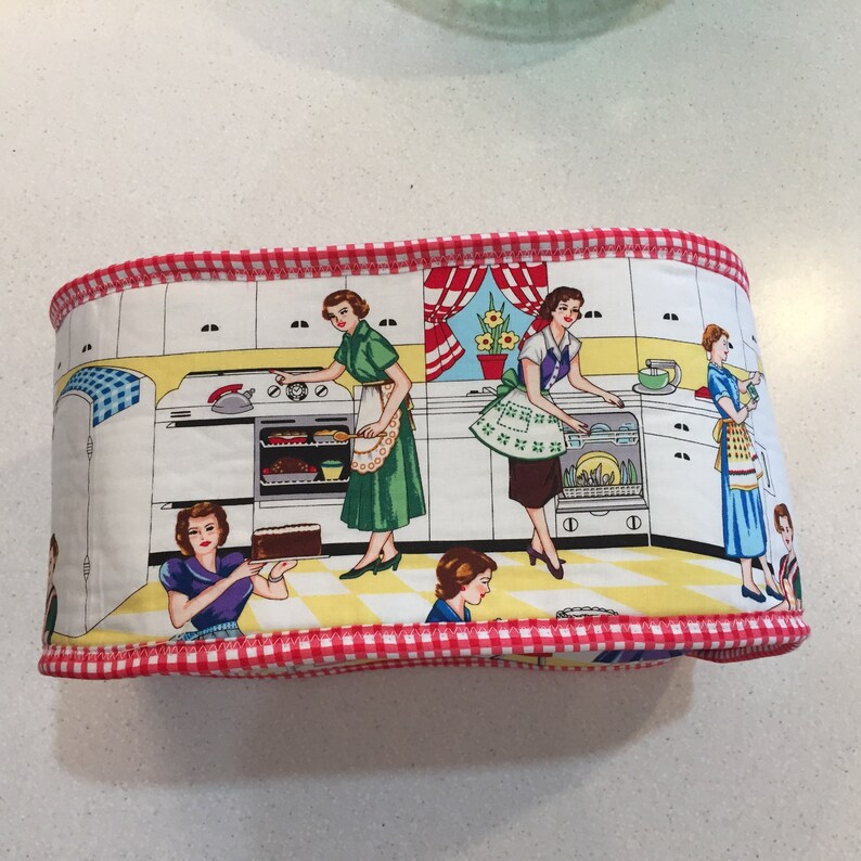May include: A red and white checkered fabric kitchen themed storage bin with a white background and images of women in a kitchen. The bin has a red and white checkered trim around the edges.