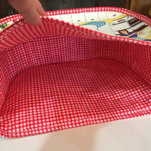 May include: Red and white gingham fabric lined storage basket with a colorful retro print on the outside.