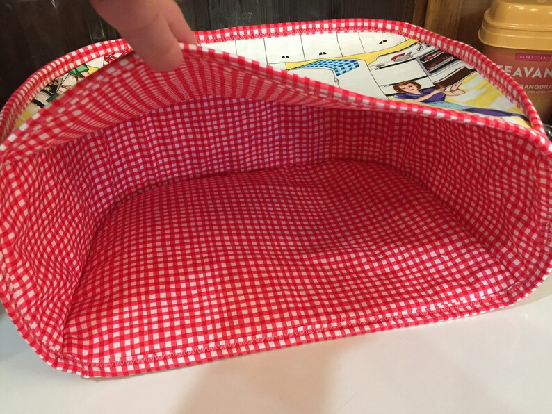 May include: Red and white gingham fabric lined storage basket with a colorful retro print on the outside.