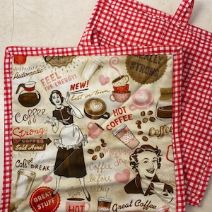 May include: Two red and white checkered pot holders with a coffee themed design. One pot holder features a woman in a brown dress holding a coffee cup and the text "Coffee Strong Sold Here!" The other pot holder features a woman in a brown dress holding a coffee cup and the text "Great Coffee".