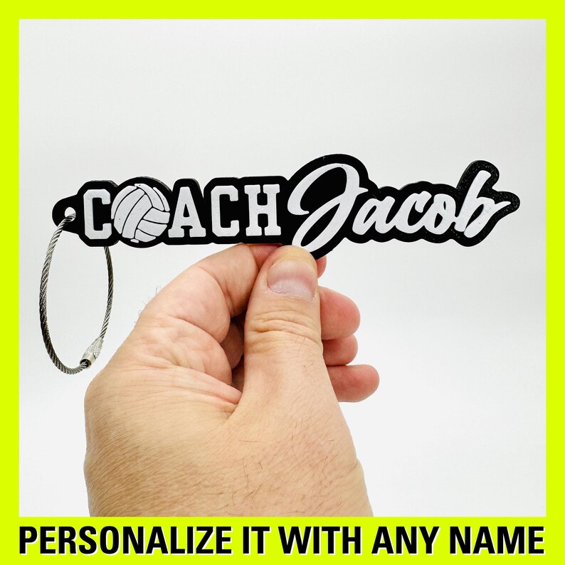 May include: Black keychain with a white volleyball and the text "COACH Jacob" in white lettering. The keychain has a silver metal ring.