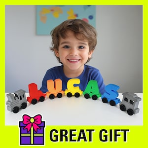 May include: A young boy is playing with a toy train that spells out his name, "LUCAS". The train is made of colorful plastic letters and has a gray and black engine. The boy is smiling and looks happy. The train is on a white surface.  Great gift.