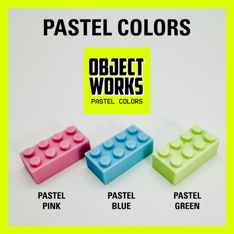 May include: Three pastel colored plastic toy building blocks. The blocks are pink, blue, and green. The blocks are arranged in a row from left to right. The text "OBJECT WORKS PASTEL COLORS" is visible above the blocks.